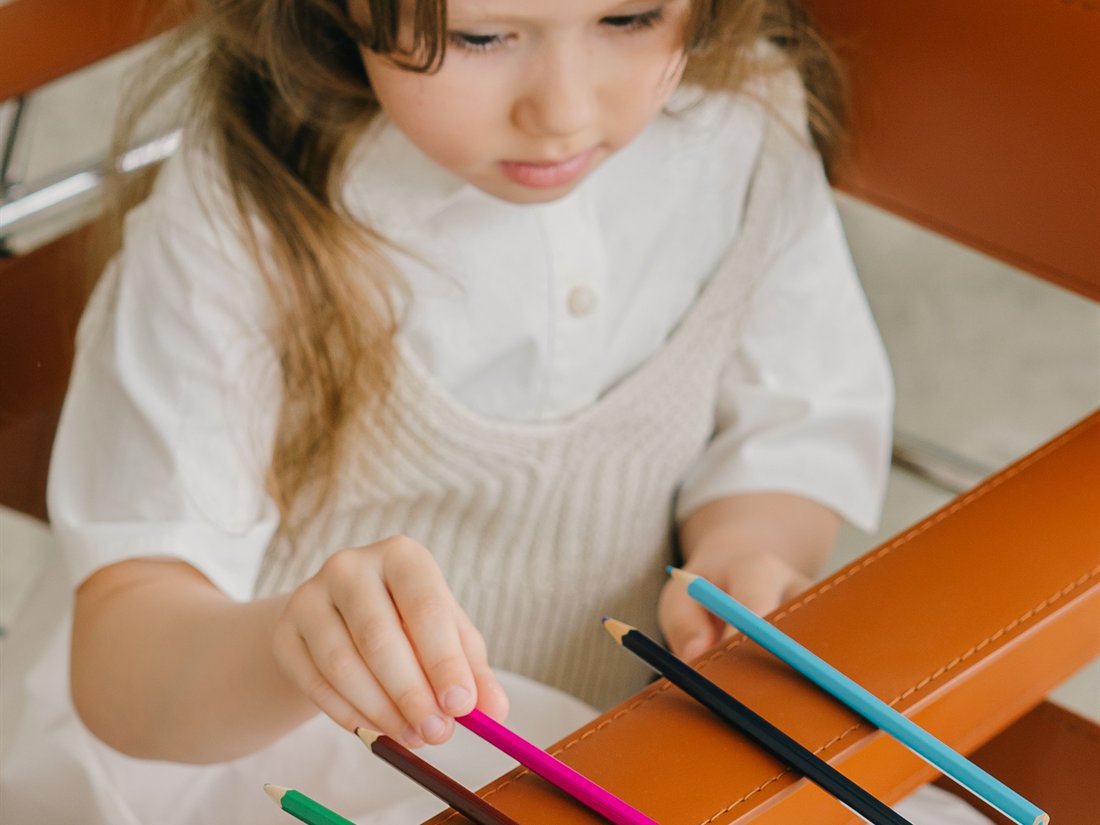 Niña ordenando lápices de colores en una actividad de secuenciación y planificación